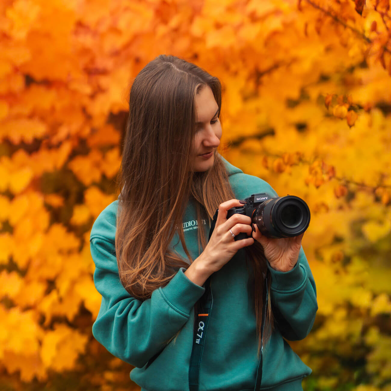 Macro photographer, Kristīne Zāle, known as @macro.viewpoint in Autumn scenery with her Sony a7 IV camera and a macro lens on